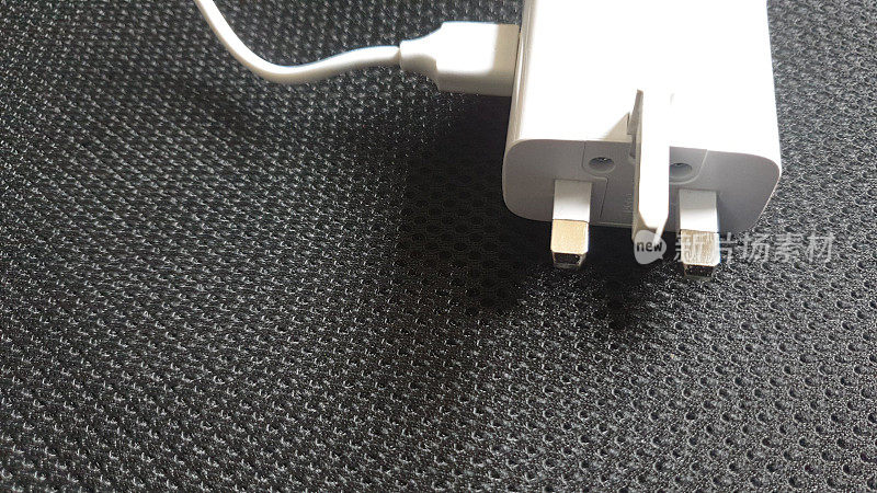 白色USB电缆和UK 3针插头上的黑色背景与复制空间